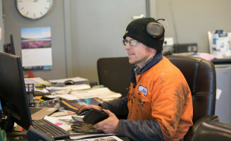 Welder at work on computer