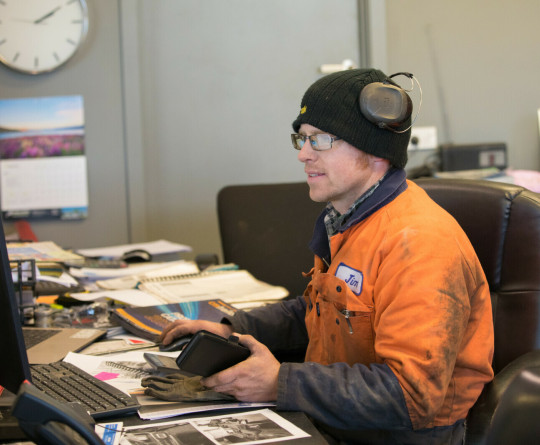 Welder at work on computer